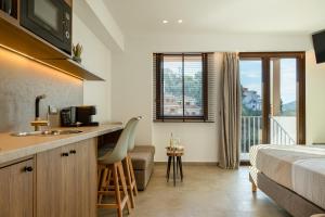 ein Hotelzimmer mit Bett und eine Küche mit Spüle in der Unterkunft Sunstar Suites in Syvota + 45 Fotos
