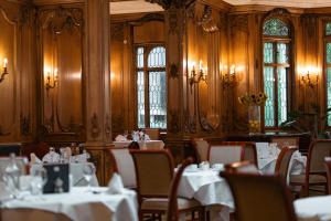 a restaurant with white tables and chairs and windows at White Swan Hotel in Alnwick