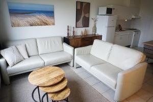 a living room with two white couches and a table at Kustverhuur, Oude manege Nieuwvliet, Nieuwvliet 1 - 2 in Nieuwvliet