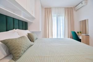 a bedroom with a large bed with a green headboard at Apartments Sonja in Tučepi