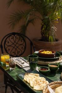 a table with a green table cloth with food on it at Riad Le Saadien ,Adult only in Marrakesh