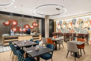 a restaurant with tables and chairs and a bar at Danubius Hotel Hungaria City Center in Budapest +36 photos
