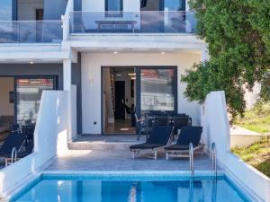 a house with a swimming pool and some chairs at Villas Kaiafa “Ismini” in Polychrono