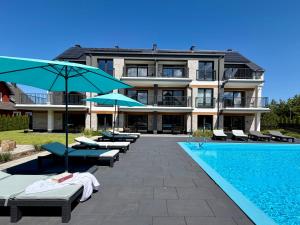 a hotel with a swimming pool with chairs and umbrellas at Inny Klimat in Rowy