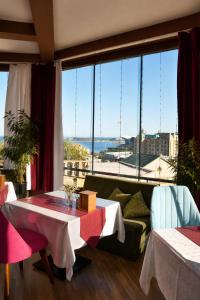 a room with two tables and a couch and large windows at Old Town Hotel in Baku