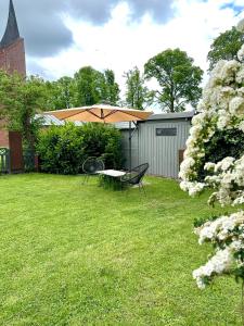 a table and chairs in a yard with an umbrella at Elbsleep in Dömitz