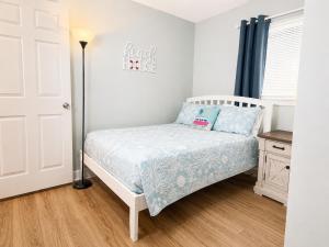 a small bedroom with a bed and a lamp at Family Getaway - Boardwalk to the Beach, 3 pools, Tennis in Hilton Head Island