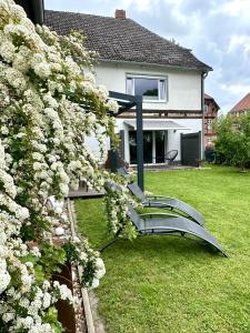 a house with a bench in a yard with flowers at Elbsleep in Dömitz