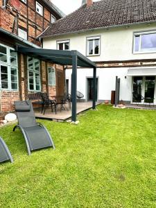 a patio with two chairs on a lawn in front of a house at Elbsleep in Dömitz