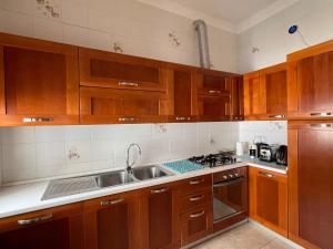 a kitchen with wooden cabinets and a sink at Aurora House in Càbras