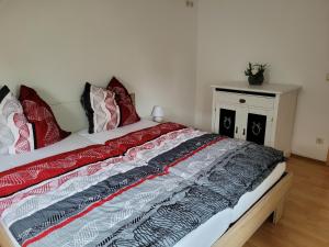 a bedroom with a bed with red and black pillows at Bella Vista in Burgstaedt