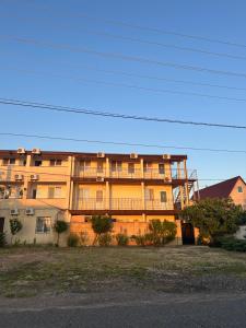 a large apartment building in front of a building at Villa Bossa in Zatoka