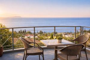 a table and chairs on a balcony with a view of the ocean at Dagos Rooms in Dhërmi