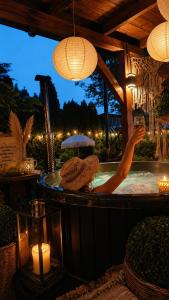 a person in a hot tub with a glass of wine at Agroturystyka u Lusi in Rytel