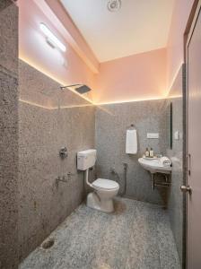 a bathroom with a toilet and a sink at Tapasya Palace in Gorakhpur