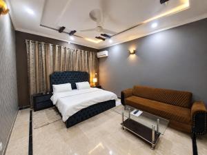 a bedroom with a bed and a couch at Canvas 430 in Islamabad