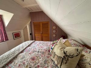 a bedroom with a large bed in a attic at Loch Ness village cottage for 2 with free parking & pets welcome in Drumnadrochit