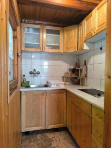 a kitchen with wooden cabinets and a sink at Brunarica Marička in Idrijska Bela