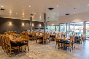 a dining room with wooden tables and chairs at Nes Ammim Hotel in Nes Ammim