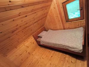 a bedroom with a bed in a wooden room at Brunarica Marička in Idrijska Bela