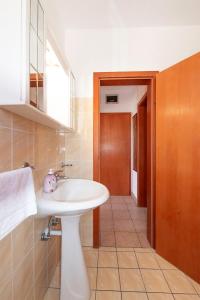 a bathroom with a white sink and a mirror at Apartments Silvia in Novalja