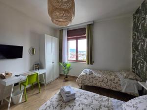 a room with two beds and a desk and a window at B&B La Rotonda in Frattamaggiore