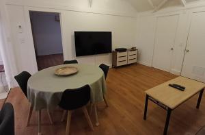 a room with a table with chairs and a television at Fairview Retreat in Clunes +5 photos
