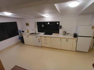 a kitchen with white cabinets and a white refrigerator at Fairview Retreat in Clunes
