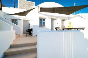 a white house with white walls and stairs at Imera Vista Suites in Imerovigli