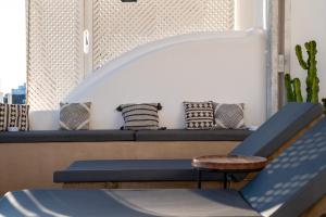 a seating area with a bench and a stool at Imera Vista Suites in Imerovigli
