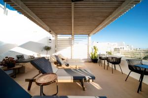 a balcony with chairs and tables on a building at Imera Vista Suites in Imerovigli