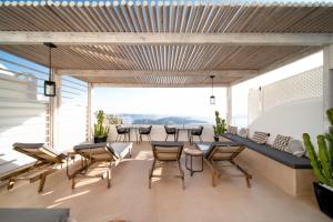 a room with chairs and a table and a couch at Imera Vista Suites in Imerovigli +6 photos