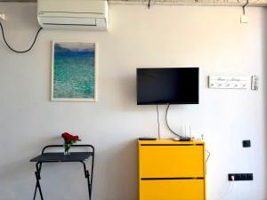 a room with a yellow dresser and a tv on a wall at Sunrise Panorama Terrace in Ozurgetʼi