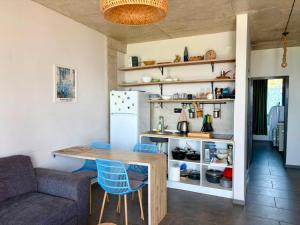 a kitchen with a table and chairs and a refrigerator at Sunrise Panorama Terrace in Ozurgetʼi
