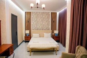 a bedroom with a bed and two tables and a chair at Khazri Resort & Villas in Baku