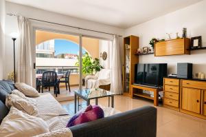 a living room with a couch and a television at Escondite Brisa Marina in Calpe