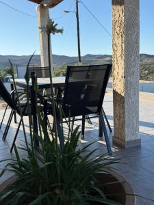a patio with a table and chairs and a plant at Kalithea Apartement in Palekastron