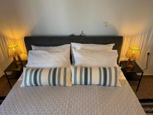 a bed with two pillows on it with two lamps at Kalithea Apartement in Palekastron