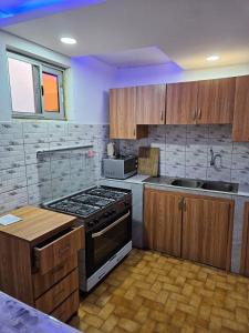 a kitchen with wooden cabinets and a stove top oven at Le Rêve d'Or in Lomé