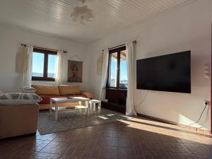 a living room with a flat screen tv on a wall at Kalithea Apartement in Palekastron
