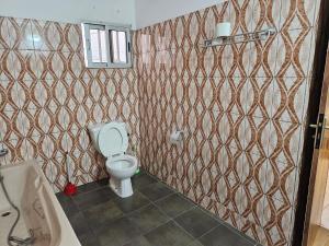 a bathroom with a toilet and a sink and a tub at Le Rêve d'Or in Lomé +25 photos