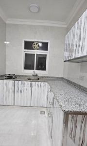 a kitchen with marble counter tops and a window at Sahalnoot flats in Salalah