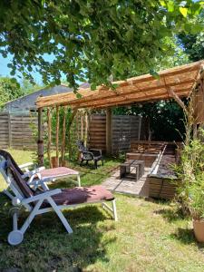 a patio with a chair and a wooden pergola at Le Cosy Cabarieu in Saint-André-de-Cubzac