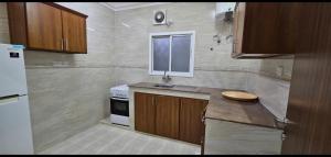 a kitchen with a counter and a sink and a window at Sahalnoot flats in Salalah