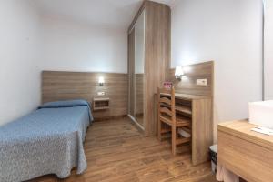 a bedroom with a bed and a desk and a table at Pensión San Andrés I in Jerez de la Frontera