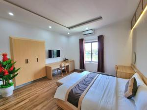 a bedroom with a large bed and a desk at Royal Homestay And Coffee in Thôn Lại Thê