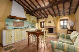 a kitchen with a table and a living room with a couch at Borgo Tignano in Casole dʼElsa