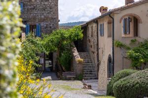 an old stone house with a bench in a yard at Borgo Tignano in Casole dʼElsa