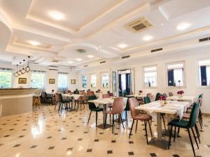 a dining room with tables and chairs and windows at All inclusive Villa Four Pearls in Trogir