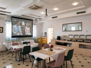 a dining room with tables and a projection screen at All inclusive Villa Four Pearls in Trogir